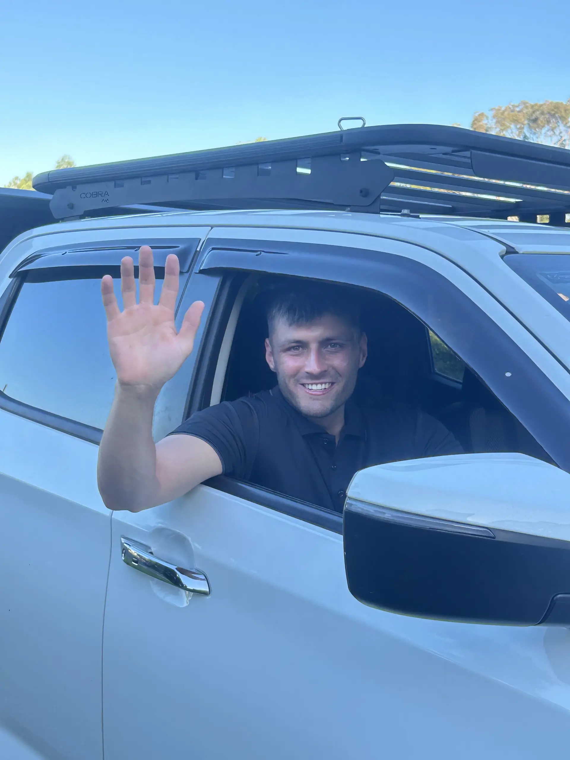 Ben Artini waving from the window of his work ute