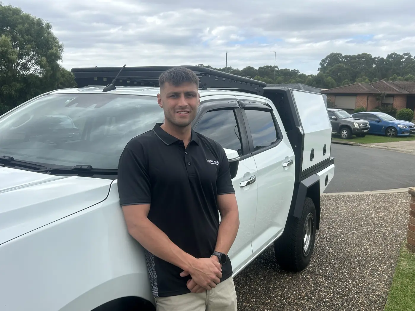 Ben Artini standing beside his ute in a Rush Hour Plumbing polo