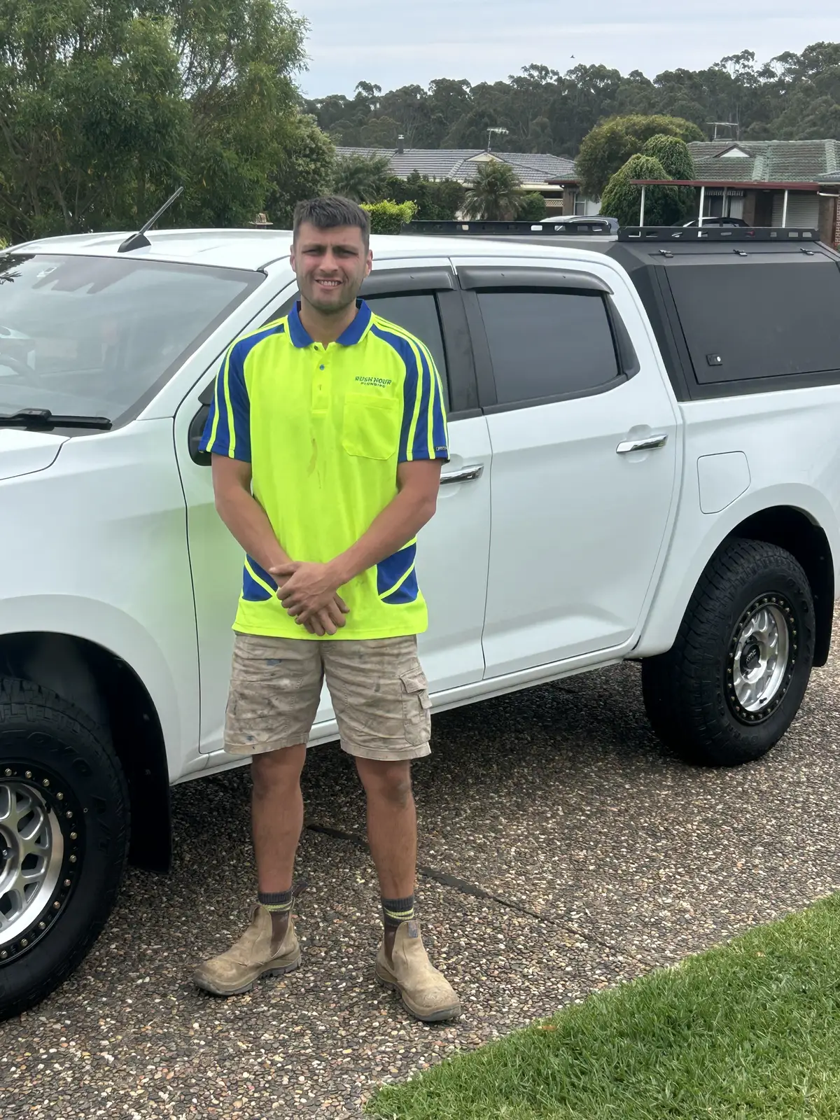 Ben in hi-vis standing in front of a work ute, early in his decade on the tools