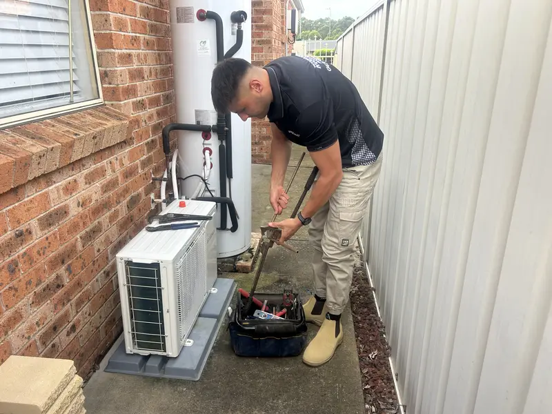 A hot water unit being fitted and tested